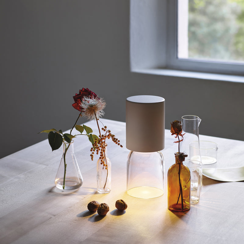 Oppladbar lampe fra Luceplan, Nui Mini med en klokke i  krystallglass